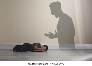 Child Abuse. Father Yelling At His Son. Shadow Of Man On Wall