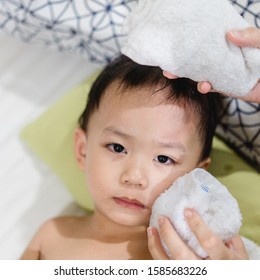 Child Accident In Head.Toddler Boy Head Accident And Mom Holding Ice Pack On His Head In Room.Little Boy Using Cold Compress In Medical Exam Room Receiving First Aid.