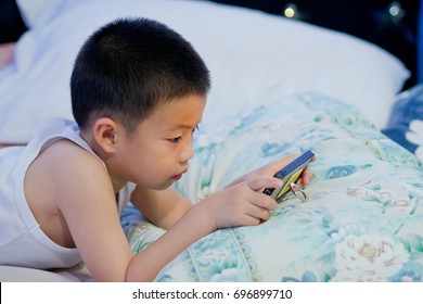 Child Addicted Phone. Asian Boy Playing Smartphone / Kid Use Telephone
