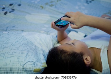 Child Addicted Phone. Asian Boy Watching And Playing Smartphone / Kid Use Telephone
