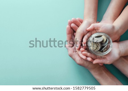 child and adult holding money jar, donation, saving, fundraising charity, family finance plan, inflation, superannuation concept