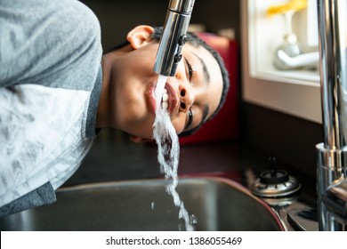 Child Afro American Boy Take Water On His Mouth And Drink In A Kitchen.