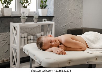 Child after back massage treatment in therapy clinic relaxing. Kid Body Treatment, Spa and healthcare concept. Pain relief. human back, boy spine copy space