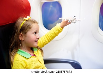 Child In Airplane. Kid In Air Plane Sitting In Window Seat. Flight Entertainment For Kids. Traveling With Young Children. Kids Fly And Travel. Family Summer Vacation. Little Girl With Toy In Airplane