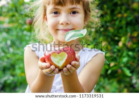 Child with an apple. Selective focus. Garden Food