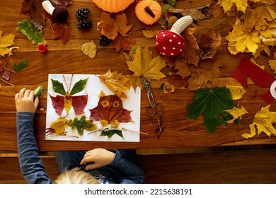 Child, applying leaves using glue, scissors, and paint, while doing arts and crafts at home or at school - Shutterstock ID 2215638191