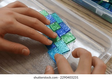A child arranging sheet glass in a glass fusing workshop