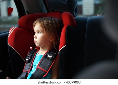 Child In Auto Baby Seat In Car Looking At Window