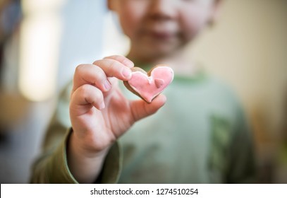 Child Baby Boy Holding Pink Ginger Cookie In Your Hand . Heart Ginger Cookie. Valentine Day Concept. About Love