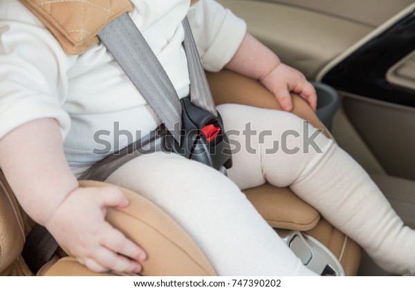 child in a baby car seat.\
Isofix clamping. beige car seat in a bright salon. Protection in\
the car.