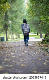 Child With A Backpack Walking Alone Outdoors.