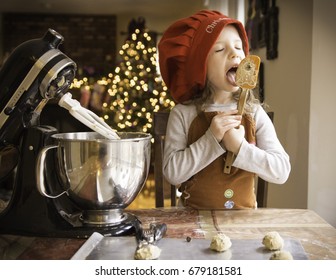 Child Baking Christmas Cookies And Eating Cookie Dough Off Spatula