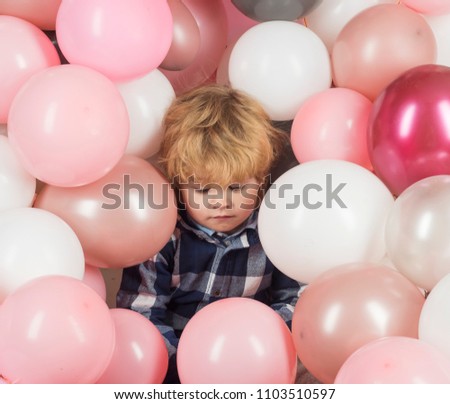 Child in balloons. Birthday party. Tired child after holiday. Celebrity life. Pink balloons and sad kid boy. Lonely child without parents is sad and frustrated. Cute baby close up, pink background