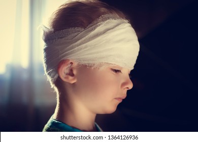 A Child With A Bandaged Head. A Pre-school Boy With A Head Injury. Childhood Trauma. Dissection Of The Scalp In Preschool Children