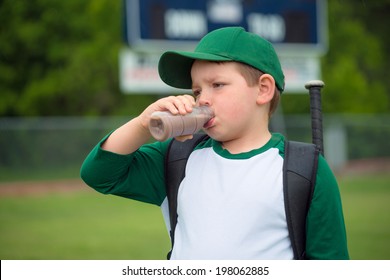 Child Baseball Player Drinking Chocolate Milk After Game