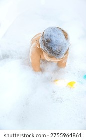 A child bathes in a bubble bath. Selective focus. Happy.