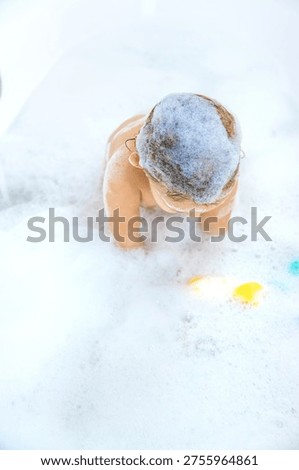 A child bathes in a bubble bath. Selective focus. Happy.
