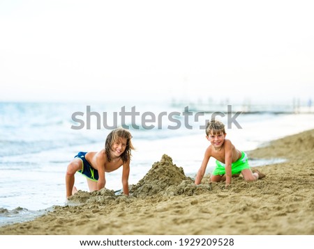 Two kids digging on the beach