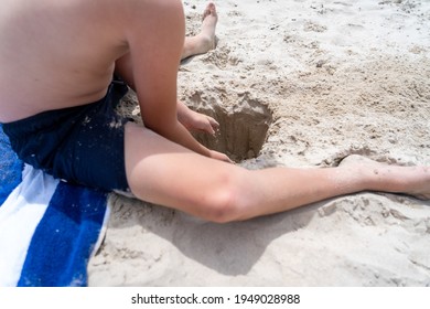 Child At Beach Digging A Hole In The Sand