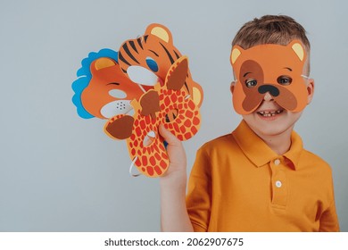 Child In A Bear Mask Holds A Set In His Hand. Set Of Assorted Animal Masks, DIY Toys, Dress Up Costumes Mask, Party Supplies, Birthday Party Favors, Play Accessories, Photo Booth Props For Kids