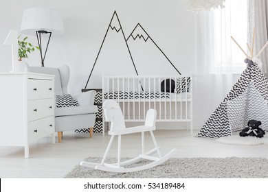 Child bedroom with decorative wall decal, dresser and cot