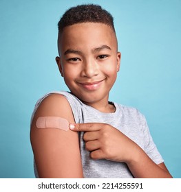 .Child Black, Band Aid And Happy Kid With Vaccine, In Blue Studio Background And Relax With Smile Or Joyful. Portrait, Boy And Adhesive Bandage With Arm Bruise, Confident And Vaccination For Health.