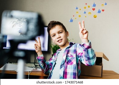 A Child Blogger Takes Pictures Of Himself On A Camera, Shows A Like, Holds A Box In His Hands, Blog, Video Recording At Home For A Blog