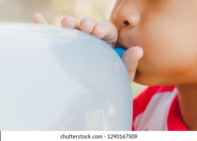 Child blowing balloon