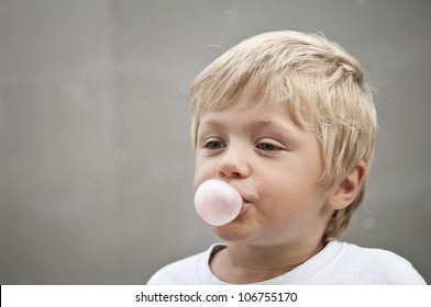 Child Blowing A Bubble Gum