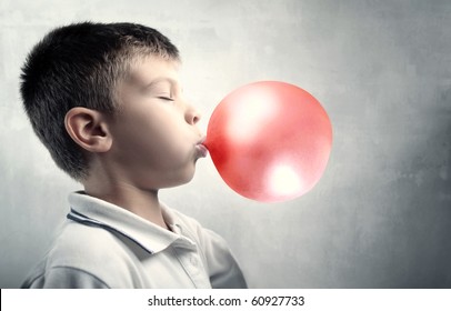 Child Blowing A Bubble Gum