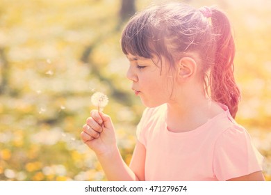 Child Blowing Dandelion