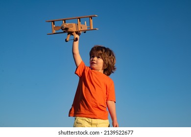 Child boy 7 year old playing with wooden toy airplane, dream of becoming a pilot. Childrens dreams. Child pilot aviator with wooden plane. - Powered by Shutterstock