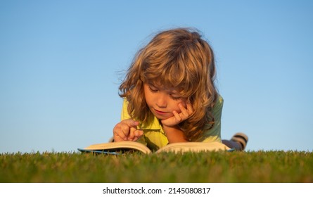 Child boy with a book in the garden. Kid is readding a book playing outdoors in summer day. Kids imagination, innovation and inspiration children.