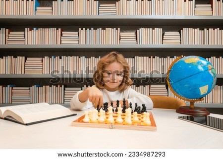 Child boy developing chess strategy, playing board game. Schoolboy chessman thinker.