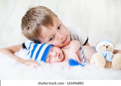 Child Boy Embracing At Sleeping Newborn Baby Brother