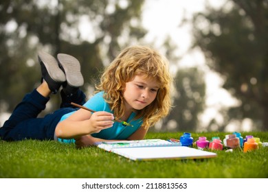 Child Boy Enjoying Art And Craft Drawing In Backyard Or Spring Park. Children Drawing Draw With Pencils Outdoor. Happy Child Playing Outside. Drawing Summer Theme. Imagination Kids Concept.