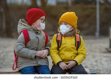 Child Boy And Girl Playing Outdoors With Face Mask Protection. School Boy Breathing Through Medical Mask. Children From Kindergarten Playing On Playground.