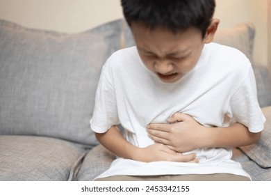 Child boy holding his stomach,kid suffering from stomachache,abdominal disease,pain ache in belly,Problem with intestine,distended belly,bloated stomach,digestive disorders or Irritable bowel syndrome - Powered by Shutterstock