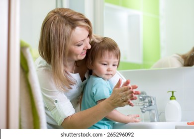 Child Boy And Mother Washing Hands With Soap In Bathroom