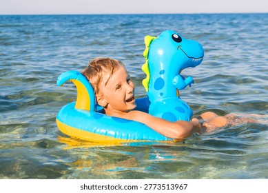 Child boy on inflatable float ring swimming enjoying in sea.Summer vacation,healthy outdoor sport activity for children.Kids beach fun.Water toy.