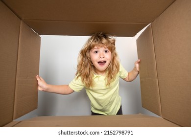 Child Boy Opening A Carton Box And Looking Inside, Unpacking Concept, Surprise Unboxing. Parcel Packaging Or Unpacking Concept.