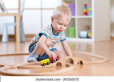 Child Boy Playing In His Room With A Toy Train