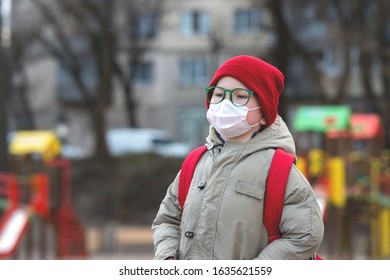 Child Boy Playing Outdoors With Face Mask Protection. School Boy Breathing Through Medical Mask. 