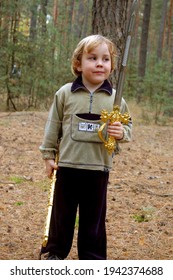 Child boy playing with sword in the forest 