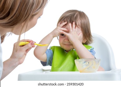 Child boy refuses to eat closing face by hands, isolated on white