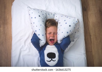Child boy sleep with alarm clock. Time to get up and go to school. Stress - Shutterstock ID 1636613275