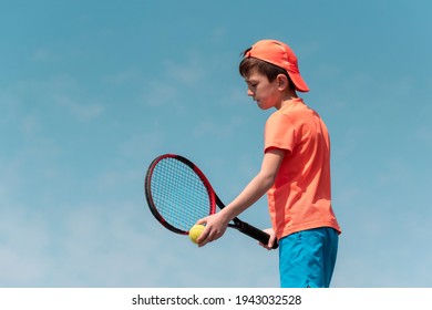 Child boy tennis player with racket and ball is focused and concentrated prepares to serve ball in match. Kids sport tennis game. Sports physical activity of children. Background copy space