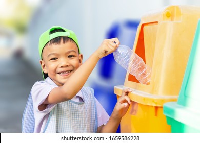 Portrait​ Image​ Of​ 5-6​ Years​ Old​ Of​ Child.​ Happy​ Asian​ Child Boy Throwing A Plastic Bottle Into A Recycle Bin.​ Save Environmental Concept.