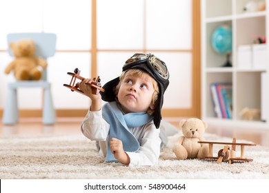 Child boy toddler playing with toy airplane and dreaming of becoming a pilot