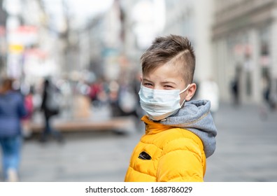 Child Boy Walking Outdoors With Face Mask Protection. School Boy Breathing Through Medical Mask Because Of Smog And Air Pollution. Pandemic Coronavirus Concept.